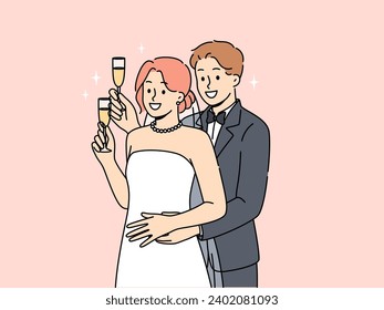 Newlyweds man and woman stand in embrace and hold glasses of champagne during wedding ceremony. Two newlyweds listen to congratulations from guests of festive event in honor of engagement