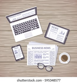 News concept. Daily information from different resources on the screens of devices and in the paper. News on laptop, tablet, phone, newspaper with coffee and glasses on a wooden desk. View from above