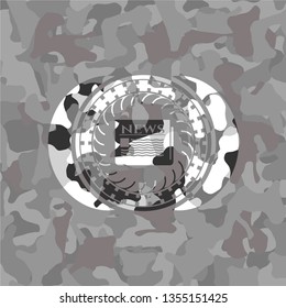 newspaper icon inside grey camo emblem
