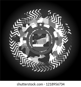 newspaper icon inside grey camouflaged emblem
