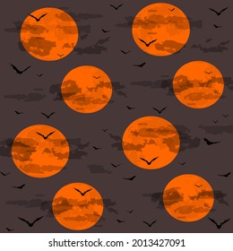 The night sky with an orange moon, clouds and bats.