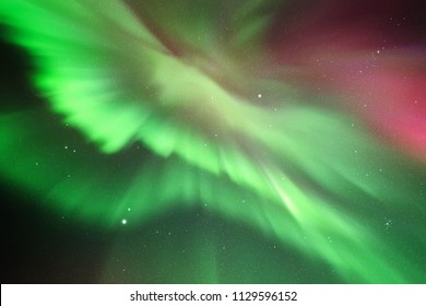 Night starry sky and Northern lights. Red green aurora borealis