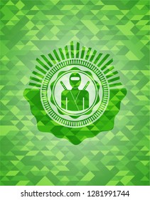 ninja icon inside green emblem with mosaic background