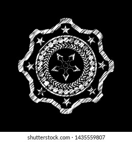 ninja star icon inside chalk emblem written on a blackboard