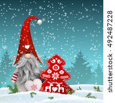 Nisser in Norway and Denmark, Tomtar in Sweden or Tonttu in Finnish, Scandinavian folklore elves, nordic christmas motive, Tomte standing in front of winter forrest in snowy landscape, with decorated