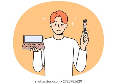 El hombre no binario aplica maquillaje y sombra de piel, sosteniendo espejo y cepillo para aplicar polvo. El hombre no binario usa cosméticos, queriendo convertirse en una chica, por el concepto de identidad de género y tolerancia