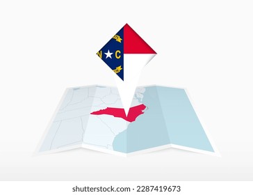 North Carolina is depicted on a folded paper map and pinned location marker with flag of North Carolina. Folded vector map.