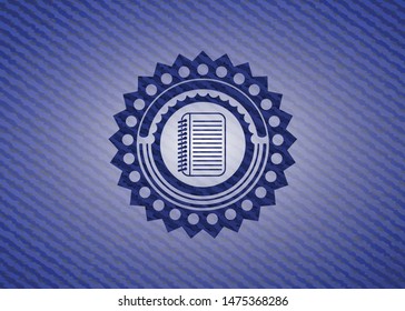 note book icon inside badge with denim background