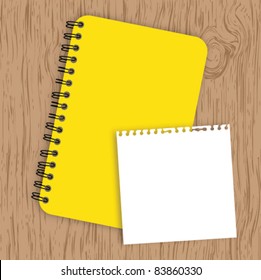 Notebook with paper on wood background
