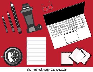 Notebook, pencil, camera on a red background