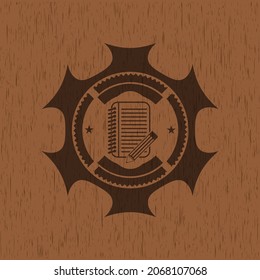 notebook with pencil icon inside badge with wood background. 