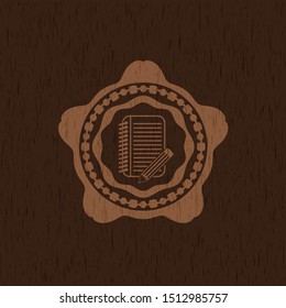 notebook with pencil icon inside vintage wood emblem