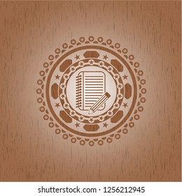 notebook with pencil icon inside wood emblem