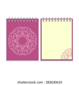 Notebook with purple cover and ornate flower white round pattern and same design element on the pages. Isolated on white background