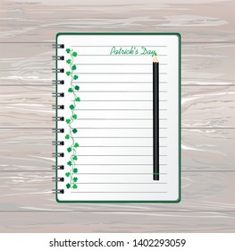 Notebook with template hand-drawn Green clover and pencil. Irish holiday - Happy St. Patrick's Day with a garland of three-leaf. Greeting card on holiday. Vector on wooden back