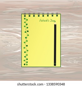 Notebook with template hand-drawn Green festive bunting with clover and pencil. Irish holiday - Happy St. Patrick's Day with a garland of three-leaf. Vector on wooden background