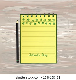 Notebook with template hand-drawn Green festive bunting with clover and pencil. Irish holiday - Happy St. Patrick's Day with a garland of three-leaf. Vector on wooden background