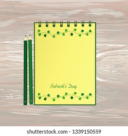 Notebook with template hand-drawn Green festive bunting with clover and pencil. Irish holiday - Happy St. Patrick's Day with a garland of three-leaf. Vector on wooden background
