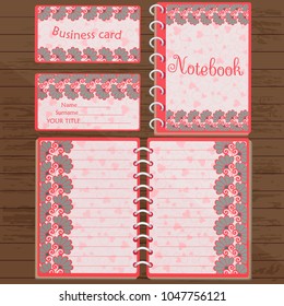 Notepad and business card with floral design on the table
