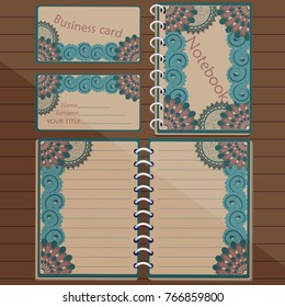 Notepad and business card with floral design on the table
