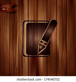 Notepad with pencil icon. Wooden background