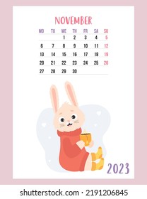 November 2023 calendar. Cute cozy rabbit in sweater and knitted socks with cup of hot tea. Vector illustration. Vertical Template. Week from Monday In English. 2023 year bunny