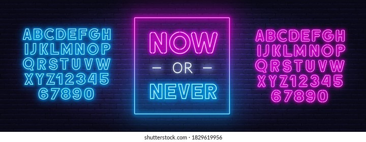 Now or never neon inspirational quote on a brick wall.