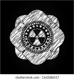 nuclear, radioactive icon inside chalkboard emblem on black board