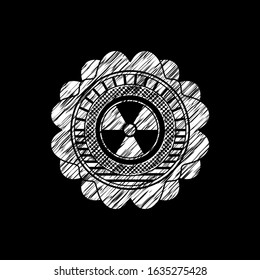 nuclear, radioactive icon inside chalkboard emblem on black board
