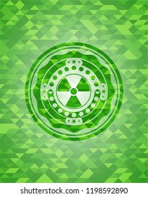 nuclear, radioactive icon inside green emblem with mosaic background