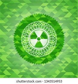 nuclear, radioactive icon inside green emblem with triangle mosaic background