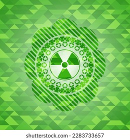 icono nuclear, radioactivo dentro del emblema verde con fondo de mosaico. 