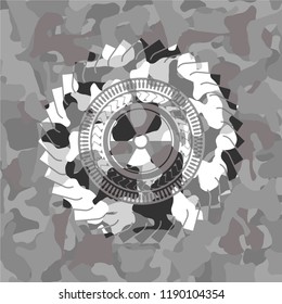 nuclear, radioactive icon inside grey camouflaged emblem