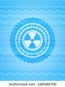 nuclear, radioactive icon inside sky blue water emblem.