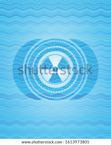 nuclear, radioactive icon inside sky blue water wave badge.