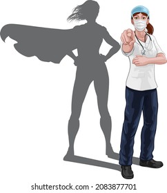 Enfermera o doctora superheroína en exfoliaciones quirúrgicas u hospitalarias con estetoscopio y enmascarar EPP. Señalar al espectador en un gesto que necesitamos o que queremos. Revelada como una superheroína por la forma de su sombra.