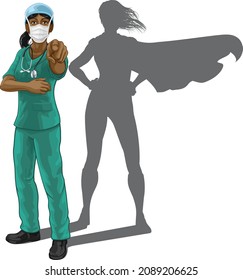 Nurse or doctor super hero woman in surgical or hospital scrubs with stethoscope and mask PPE. Pointing at viewer in a we need or want you gesture. Revealed as a superhero by the shape of her shadow.