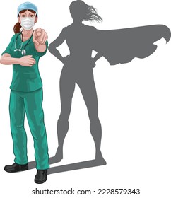 Nurse or doctor super hero woman in surgical or hospital scrubs with stethoscope and mask PPE. Pointing at viewer in a we need or want you gesture. Revealed as a superhero by the shape of her shadow.