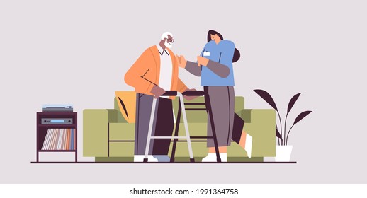 nurse or volunteer supporting elderly man with walkers home care services healthcare and social support