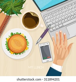 Office desk with computer, burger, coffee and laptop. Top view. Business lunch. Coffee break.
