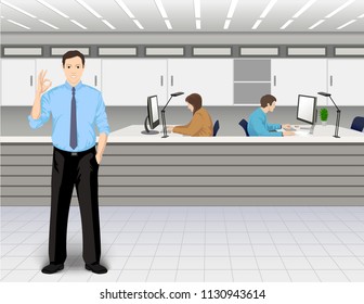Office interior. Young man shows the OK gesture. Co-workers on the background near the own computers.