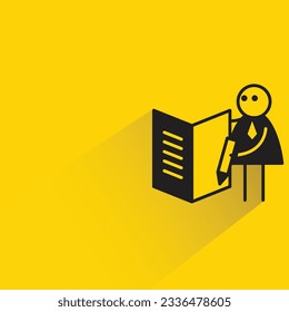 trabajador de oficina escribiendo sobre la figura del stick de libro con sombra sobre el fondo amarillo
