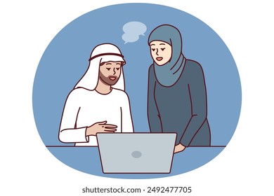 Office workers in Arabic clothing discussing business presentation from laptop. Arabic man and woman work together in corporation in dubai or emirates and conduct business negotiations via internet.