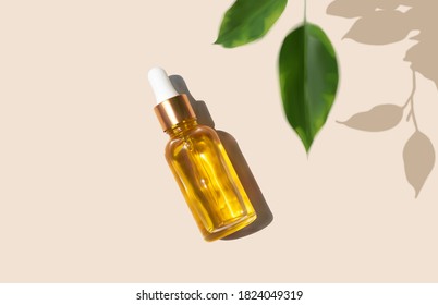 Oil serum glass bottle and defocused leaves with trendy hard shadow on beige background realistic vector illustration, top view. Aromatherapy oil, concept of natural cosmetic