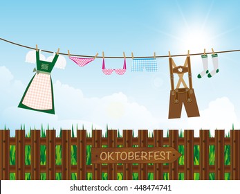 Oktoberfest Background Outdoors, Lederhosen, Dirndl, Panties, Lingerie, Socks Hanging On Clothes Line, Destination Board On Wooden Garden Fence, 