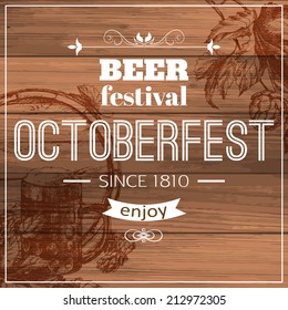 Oktoberfest typographical wooden background with hand drawn beer and hops.