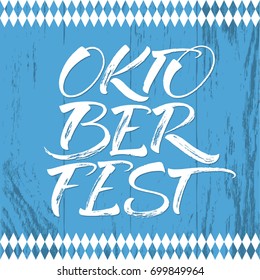 Oktoberfest white lettering on blue board texture. Handwritten modern calligraphy, brush painted letters. Vector illustration. Template for banners, posters, merchandising, cards or photo overlays.