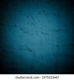 Old dark blue wall in spots, cracks, stains. Painted concrete wall in abstract grunge style. Grunge loft background texture for backgrounds, portraits, posters.