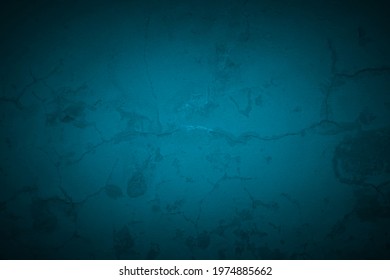 Old dark turquoise wall in spots, cracks, stains. Blue painted concrete wall in abstract grunge style. Grunge loft background texture for backgrounds, portraits, posters.