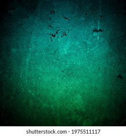 Old dark turquoise wall in spots, cracks, stains. Green painted concrete wall in abstract grunge style. Grunge loft background texture for backgrounds, portraits, posters.